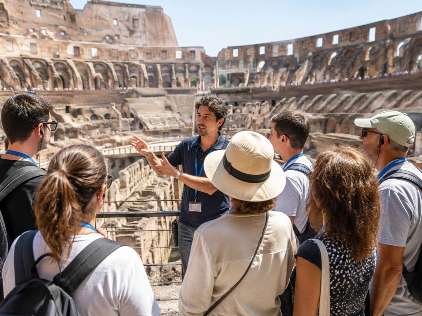 Colosseum guided tour in Rome with a tour guide explaining the ancient amphitheatre to a group of visitors.